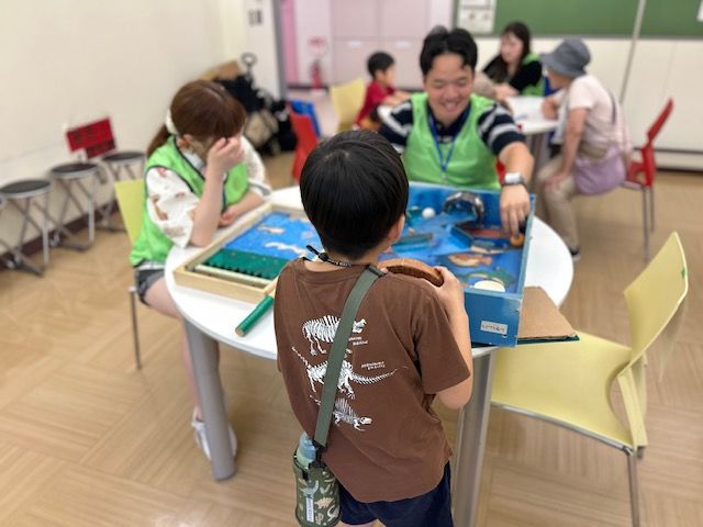 学生スタッフとこどもがボードゲームで遊ぶ様子